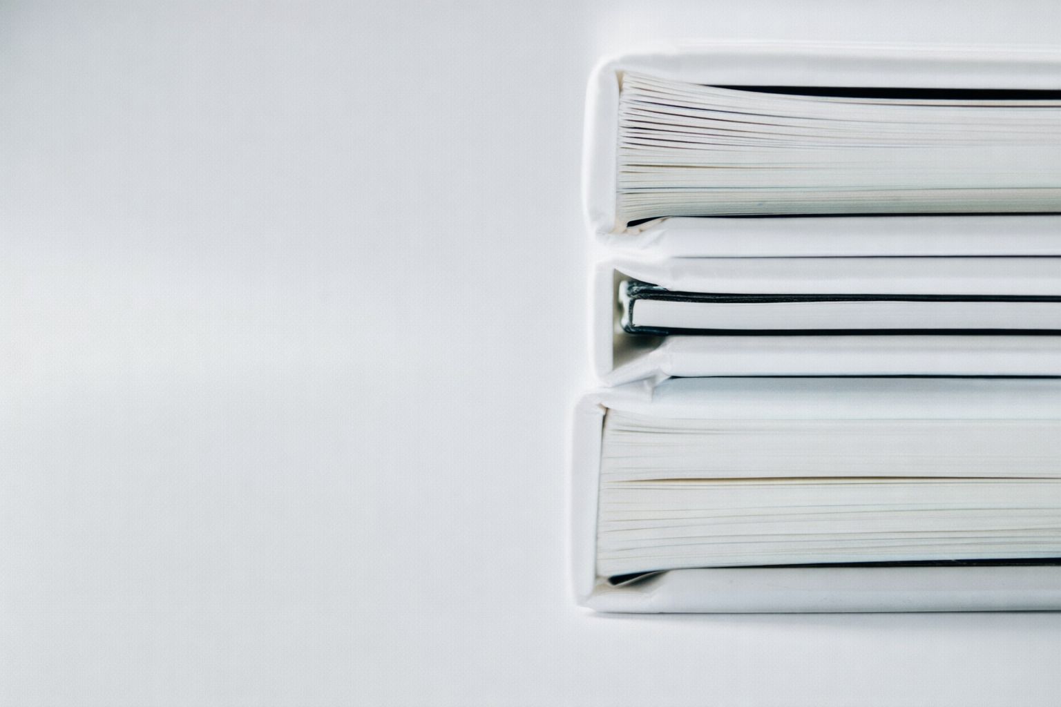 En stack med vita mappar och dokument för ansökan om företagskredit.