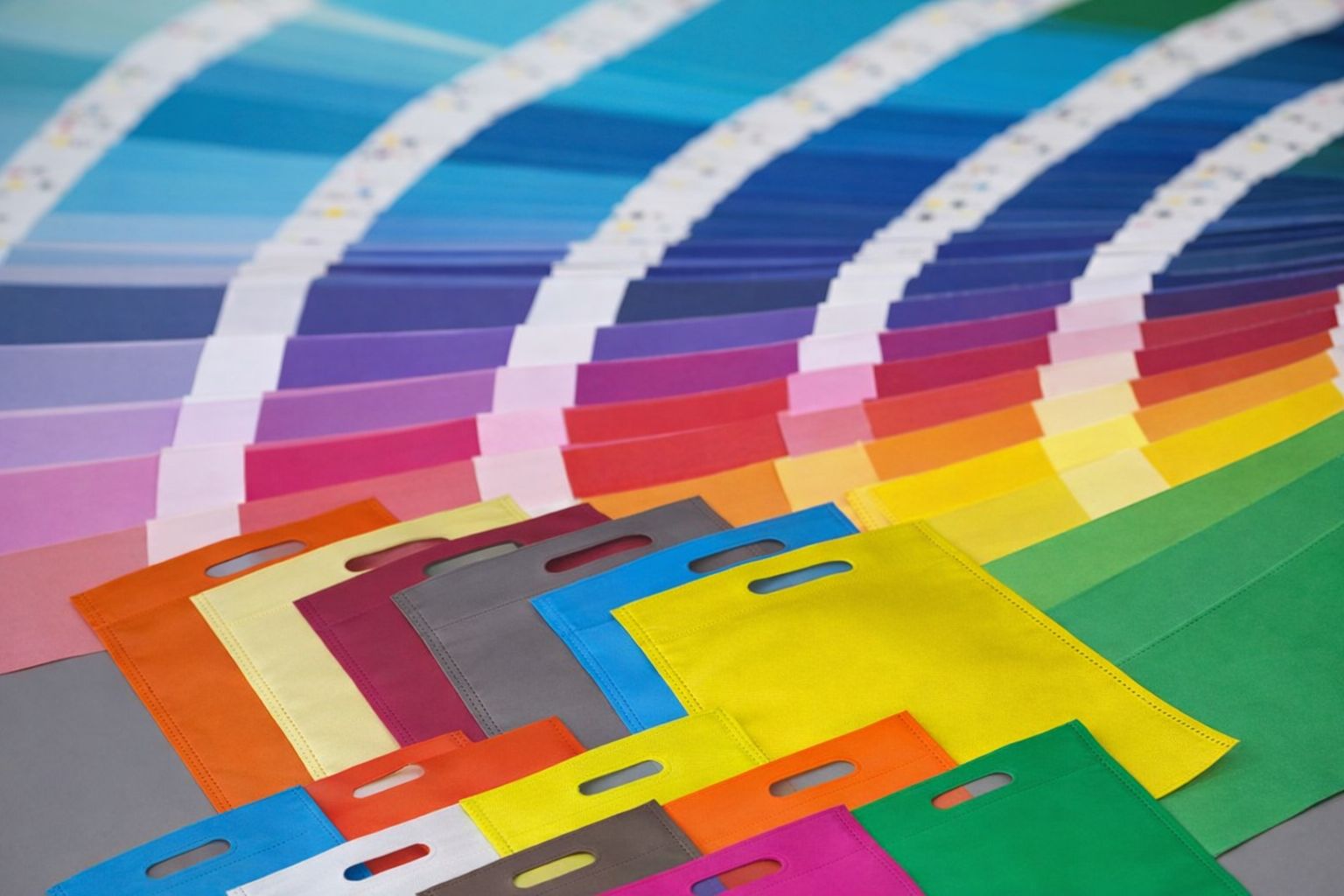 Färgstarka påsar framför en omfattande färgkarta för profilering.